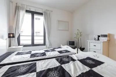 a bedroom with a black and white quilt on a bed at Cannes centre 2mins from beach stunning 3-Bed Apt in Cannes