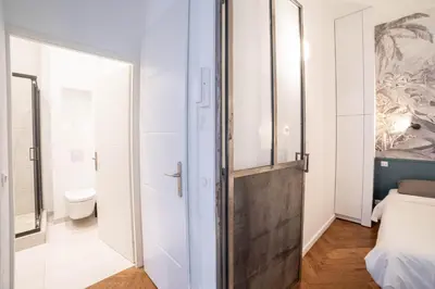 a bedroom with a door leading to a bathroom at Diamond Apartment in Cannes