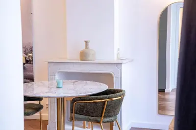 a table and chairs in a room with a fireplace at Diamond Apartment in Cannes
