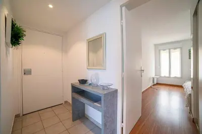 a living room with a table in a room at Les Palmiers in Cannes