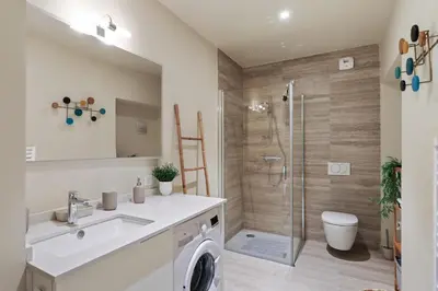 a bathroom with a shower and a sink and a washing machine at Appartement des Anges - Welkeys in Cannes