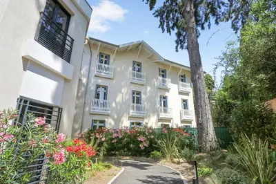 an apartment building with flowers and a tree at Appartement des Anges - Welkeys in Cannes