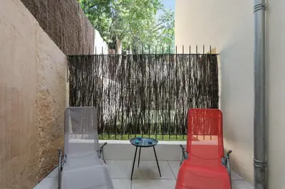 two chairs and a table in front of a fence at Appartement des Anges - Welkeys in Cannes