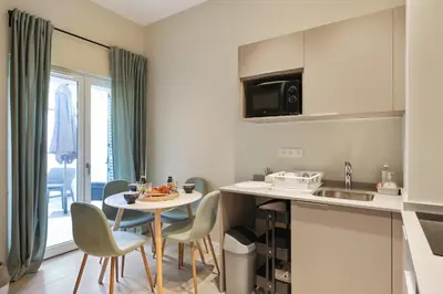 a kitchen with a small table and chairs in a room at Appartement des Anges - Welkeys in Cannes