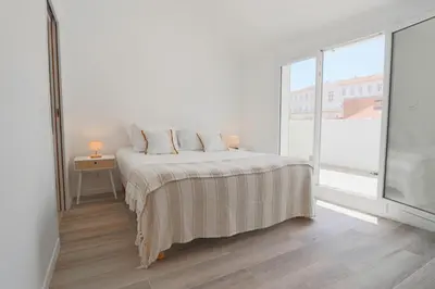a white bedroom with a bed and a large window at MEYNADIER Renovated designer apartment with rooftop in Cannes in Cannes