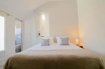 a white bedroom with a large bed with two pillows at MEYNADIER Renovated designer apartment with rooftop in Cannes in Cannes