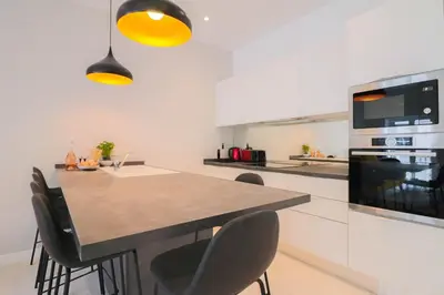 a kitchen with a table with chairs and a microwave at NAPOLEON Luxurious renovated apartment 1min from Palais in Cannes