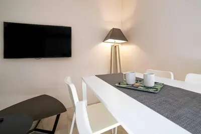 a white dining room table with two cups and a television at Coeur De Cannes in Cannes