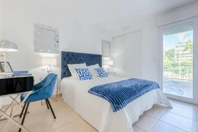 a bedroom with a bed and a desk and a window at 3-Room Apartment in Prestigious Residence in Cannes