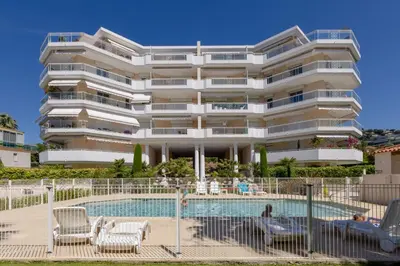 a hotel with a swimming pool and a building at 3-Room Apartment in Prestigious Residence in Cannes