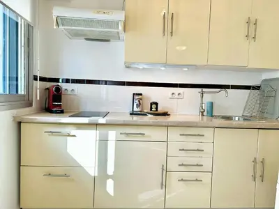 a kitchen with white cabinets and a sink at Magnifique appartement Cosy Cannes à 5mn du fameux palais du festival et ses plages in Cannes