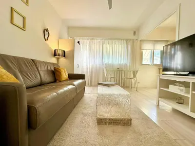 a living room with a brown leather couch and a table at Magnifique appartement Cosy Cannes à 5mn du fameux palais du festival et ses plages in Cannes