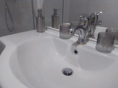 a bathroom sink with a faucet and glasses on it at Magnifique appartement Cosy Cannes à 5mn du fameux palais du festival et ses plages in Cannes