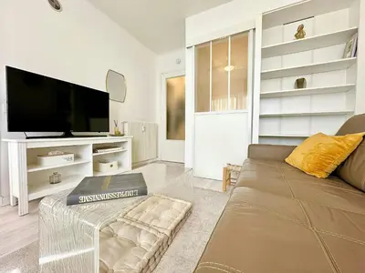 a living room with a couch and a flat screen tv at Magnifique appartement Cosy Cannes à 5mn du fameux palais du festival et ses plages in Cannes