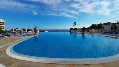 a large swimming pool with a view of the ocean at Cannes & More in Cannes