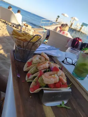 a plate of shrimp and vegetables on a table at the beach at Cannes & More in Cannes