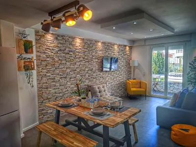 a living room with a table and a brick wall at Cannes Holiday suite à 2 pas du festival et plages in Cannes