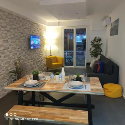 a living room with a table and a couch at Cannes Holiday suite à 2 pas du festival et plages in Cannes