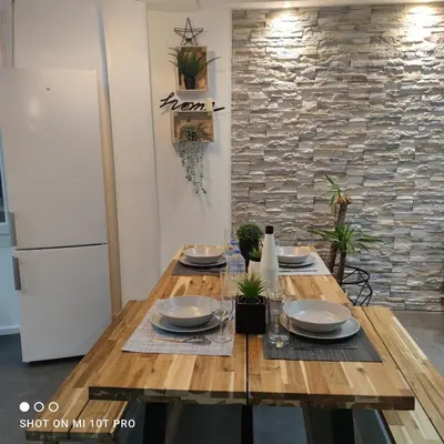 a wooden table with plates on it in a room with a refrigerator at Cannes Holiday suite à 2 pas du festival et plages in Cannes