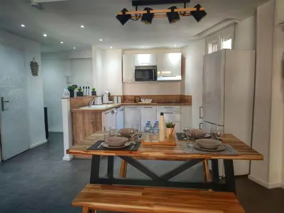 a kitchen with a wooden table and a refrigerator at Cannes Holiday suite à 2 pas du festival et plages in Cannes