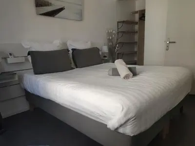 a large bed with white sheets and pillows on it at Cannes Holiday suite à 2 pas du festival et plages in Cannes