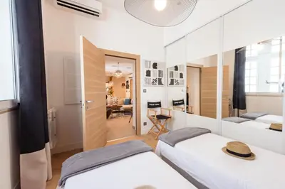 a bedroom with two beds and a living room at Cozy 2-Br Apartment 1 min from the Beaches in Cannes