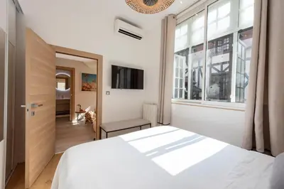 a bedroom with a white bed and a window at Cozy 2-Br Apartment 1 min from the Beaches in Cannes