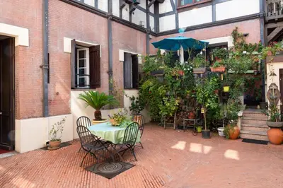 a patio with a table with chairs and an umbrella at Cozy 2-Br Apartment 1 min from the Beaches in Cannes