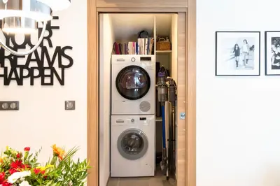 a washer and dryer in a room with a wall at Cozy 2-Br Apartment 1 min from the Beaches in Cannes