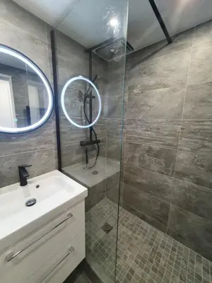 a bathroom with a shower and a sink and a mirror at Appartement en bord de mer in Cannes