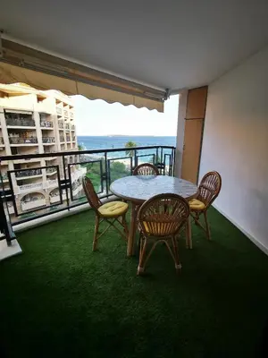 a table and chairs with a view of the ocean at Appartement en bord de mer in Cannes