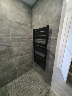 a bathroom with a shower with a tiled wall at Appartement en bord de mer in Cannes