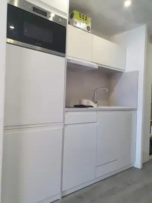 a kitchen with white cabinets and a sink at Appartement en bord de mer in Cannes
