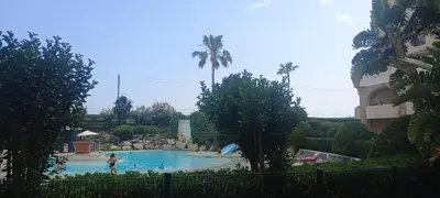 a swimming pool in a resort with palm trees at Villa Maupassant 06 Cannes in Cannes