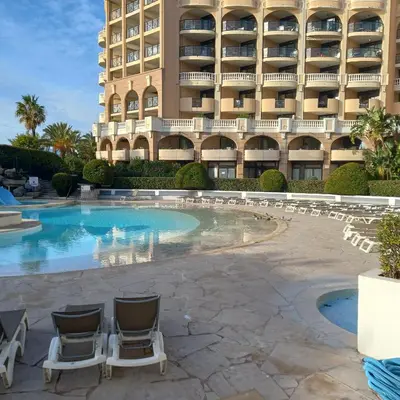a hotel with chairs and a swimming pool in front of a building at Villa Maupassant 06 Cannes in Cannes