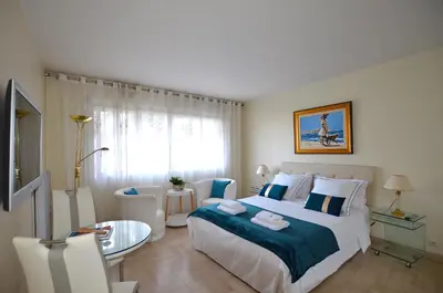 a bedroom with a large bed and a glass table at Studio Cannes Gray d'Albion in Cannes