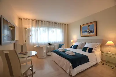 a bedroom with a bed and a table and a television at Studio Cannes Gray d'Albion in Cannes