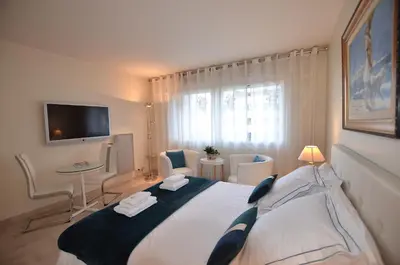 a bedroom with a large bed and a tv at Studio Cannes Gray d'Albion in Cannes
