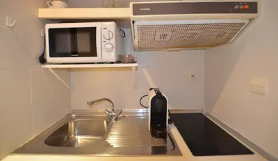 a small kitchen with a sink and a microwave at Studio Cannes Gray d'Albion in Cannes