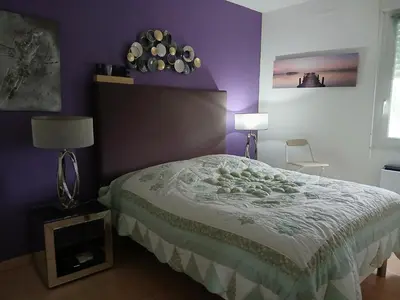 a bedroom with a bed and a purple wall at Location chambre 2 personnes chez Angela in Cannes