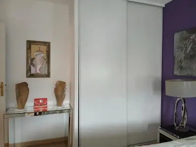 a bedroom with a sliding door and a table with a lamp at Location chambre 2 personnes chez Angela in Cannes
