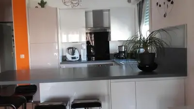 a kitchen with white cabinets and a black counter top at Location chambre 2 personnes chez Angela in Cannes