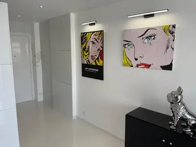 two posters on a wall in a room with a black cabinet at Ibis croisette in Cannes