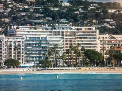 a view of a beach with a large building at Ibis croisette in Cannes