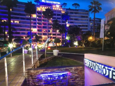 a building with a neon sign in front of it at night at Ibis croisette in Cannes