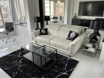 a living room with a white couch and a glass table at Ibis croisette in Cannes