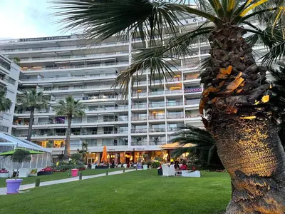 a palm tree in front of a large building at Ibis croisette in Cannes