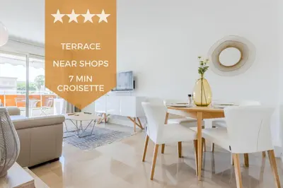 a dining room with a table and white chairs at Stylish 1-Bedroom Apartment Close to Beaches in Cannes