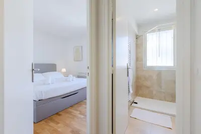 a white bedroom with a bed and a shower at Stylish 1-Bedroom Apartment Close to Beaches in Cannes