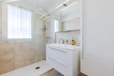 a white bathroom with a sink and a shower at Stylish 1-Bedroom Apartment Close to Beaches in Cannes